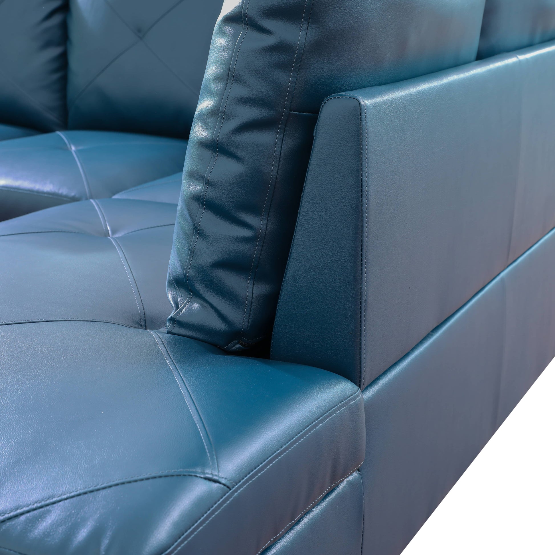 Dark teal leather sofa detail with tufted cushions and stitched seams