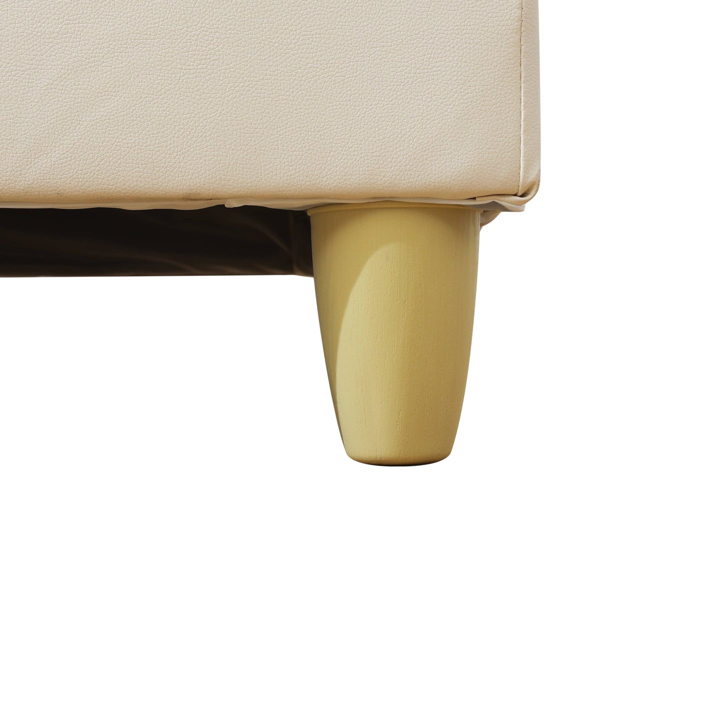 Closeup of a light cream faux leather sofa corner with a tapered wooden leg