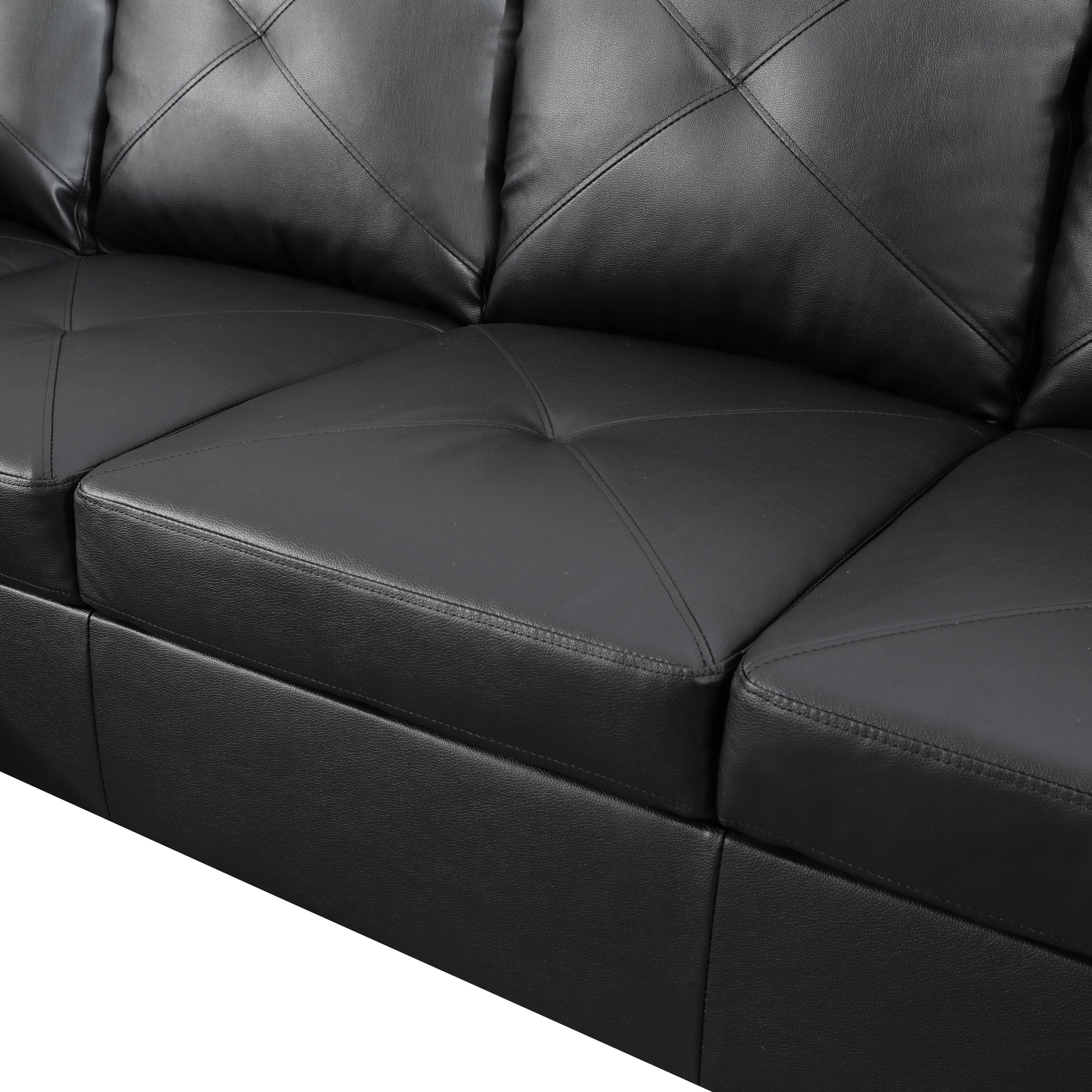 Closeup of tufted black faux leather sofa cushions