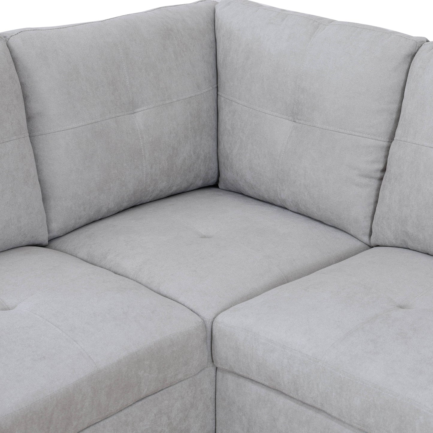 Closeup of a light grey fabric sectional sofa corner
