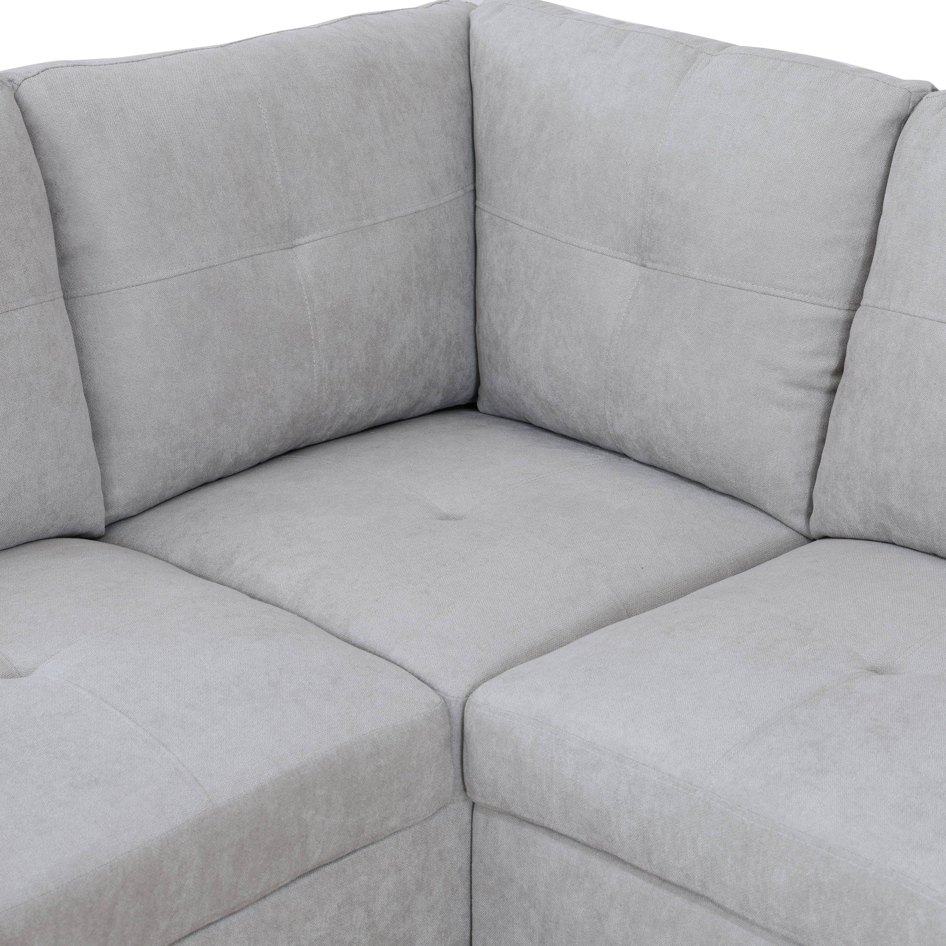 Closeup of a light grey fabric sectional sofa corner
