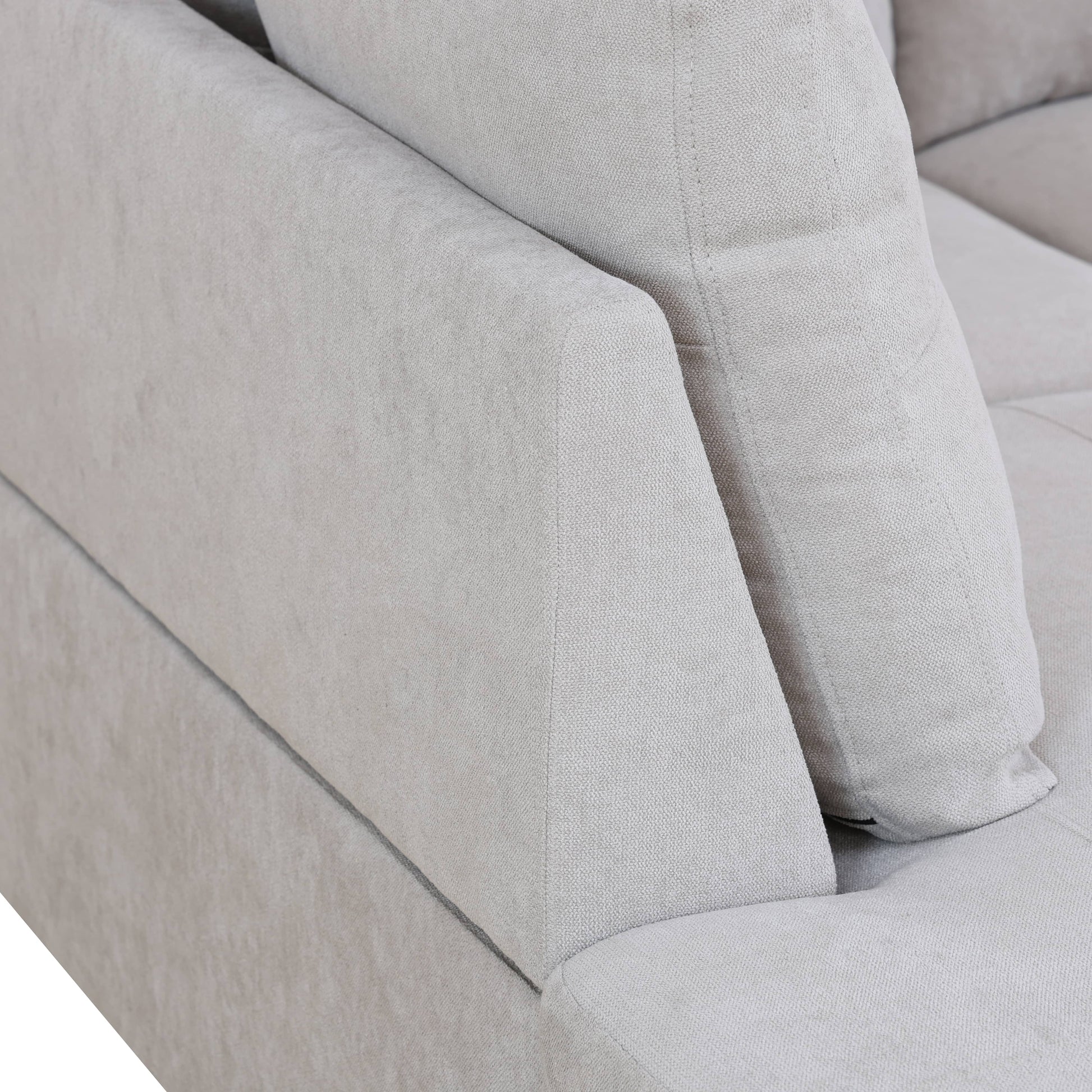 Closeup of a light gray fabric sofa armrest and cushion