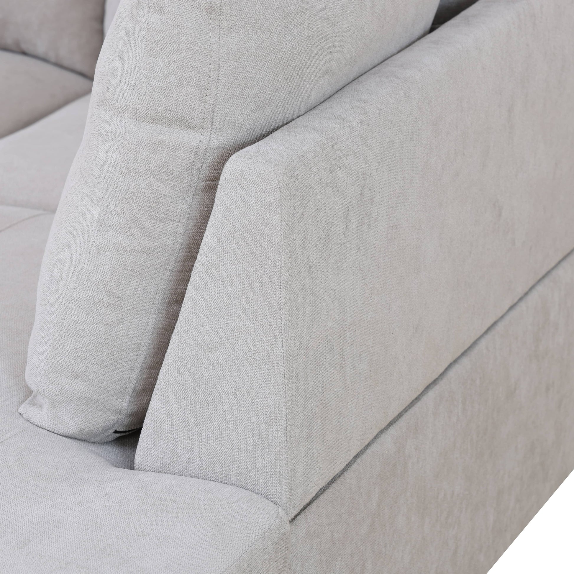 Closeup of textured light gray fabric sofa armrest and cushion
