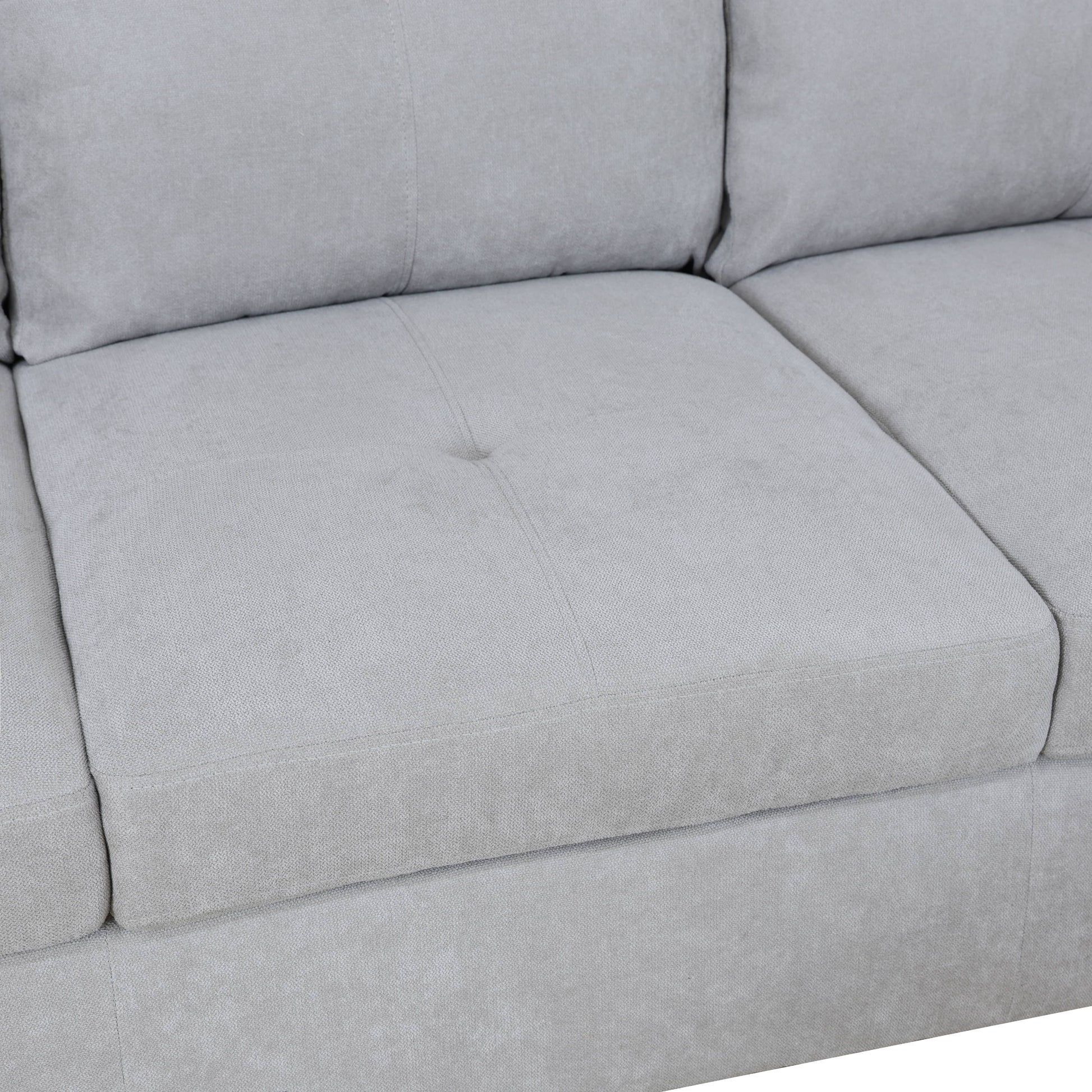 Light gray textured fabric sectional sofa cushion with button tufting