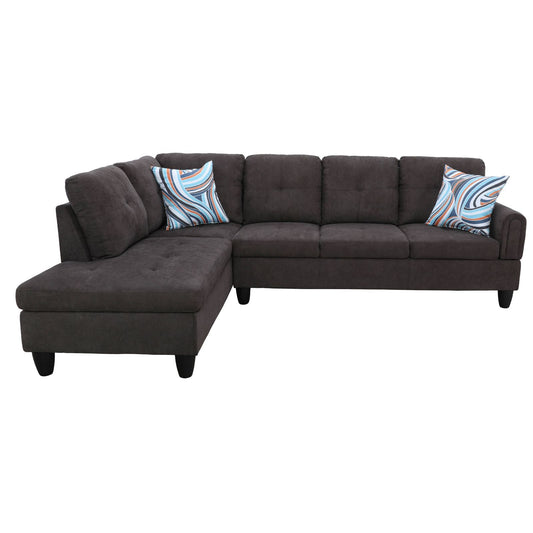 Dark gray fabric sectional sofa with tufted cushions and abstract throw pillows