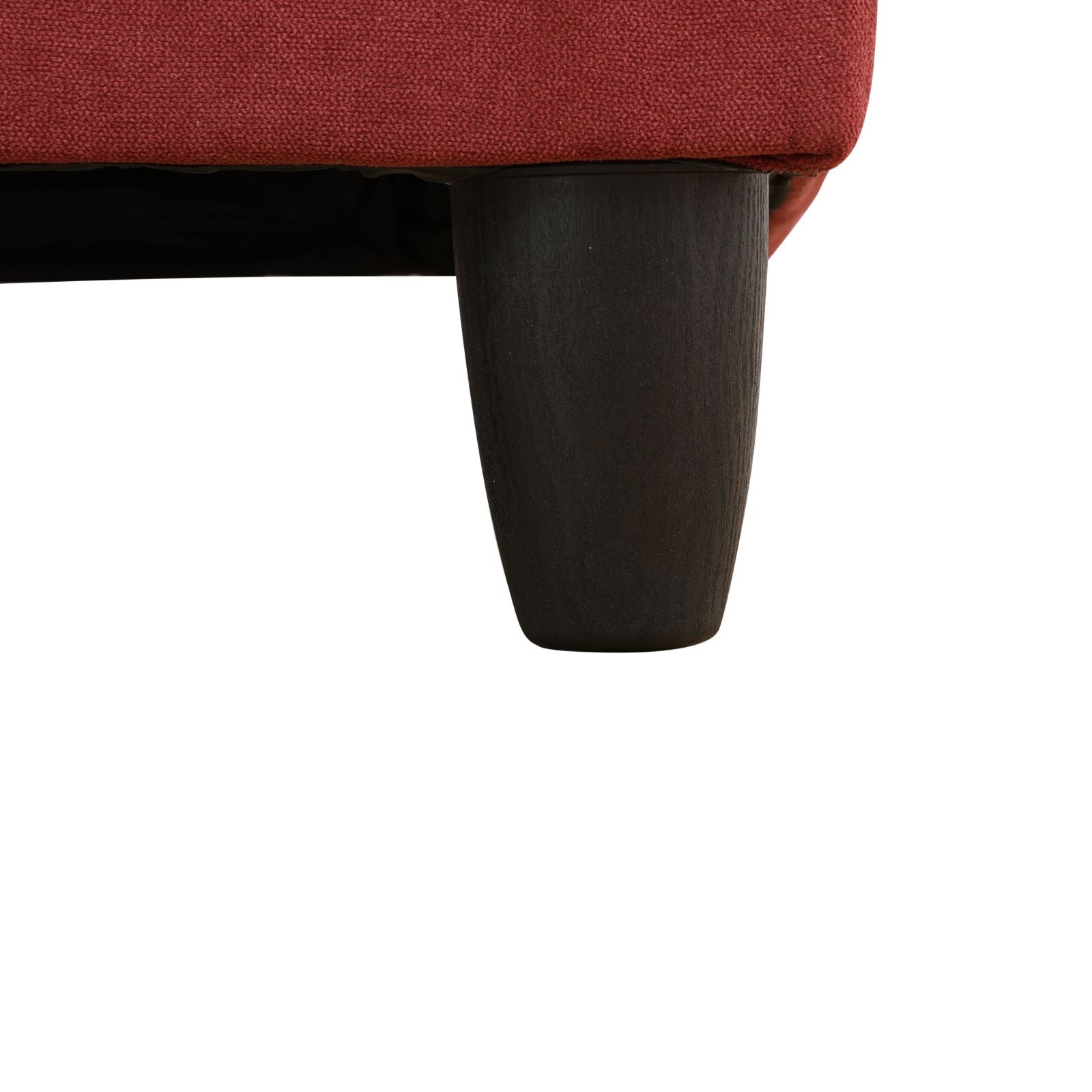 Red upholstered sofa corner with dark tapered wooden leg
