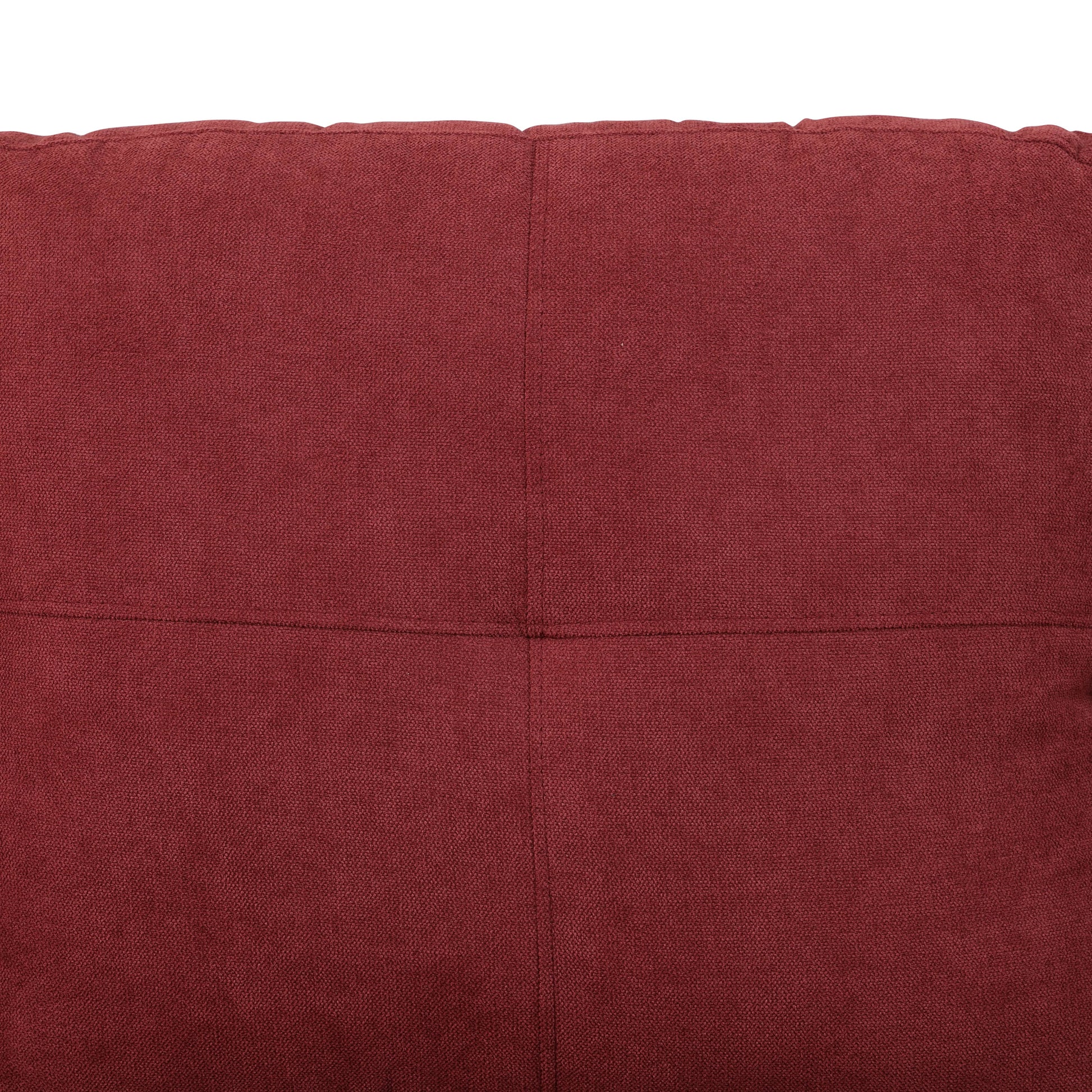 Deep red textured fabric closeup with quilted panel