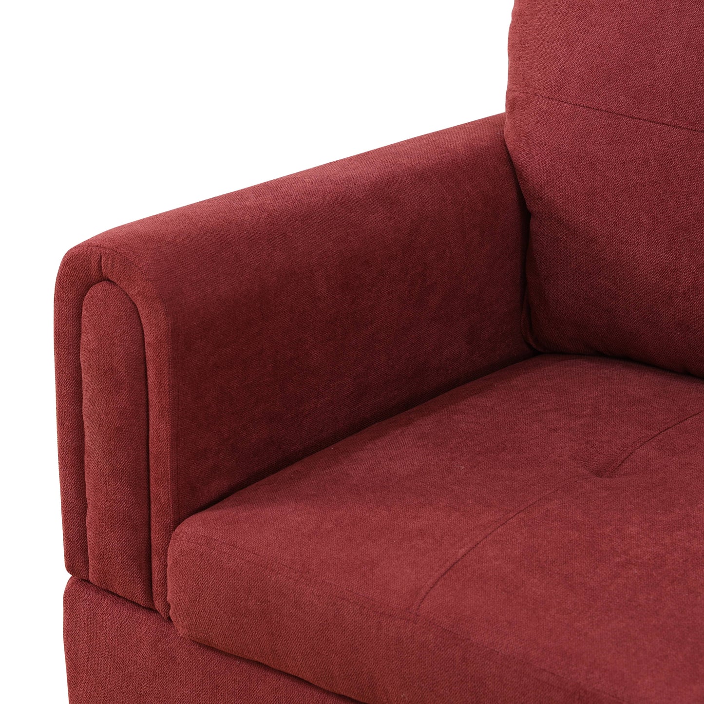 Deep red upholstered armchair detail with tufted seat and curved armrest