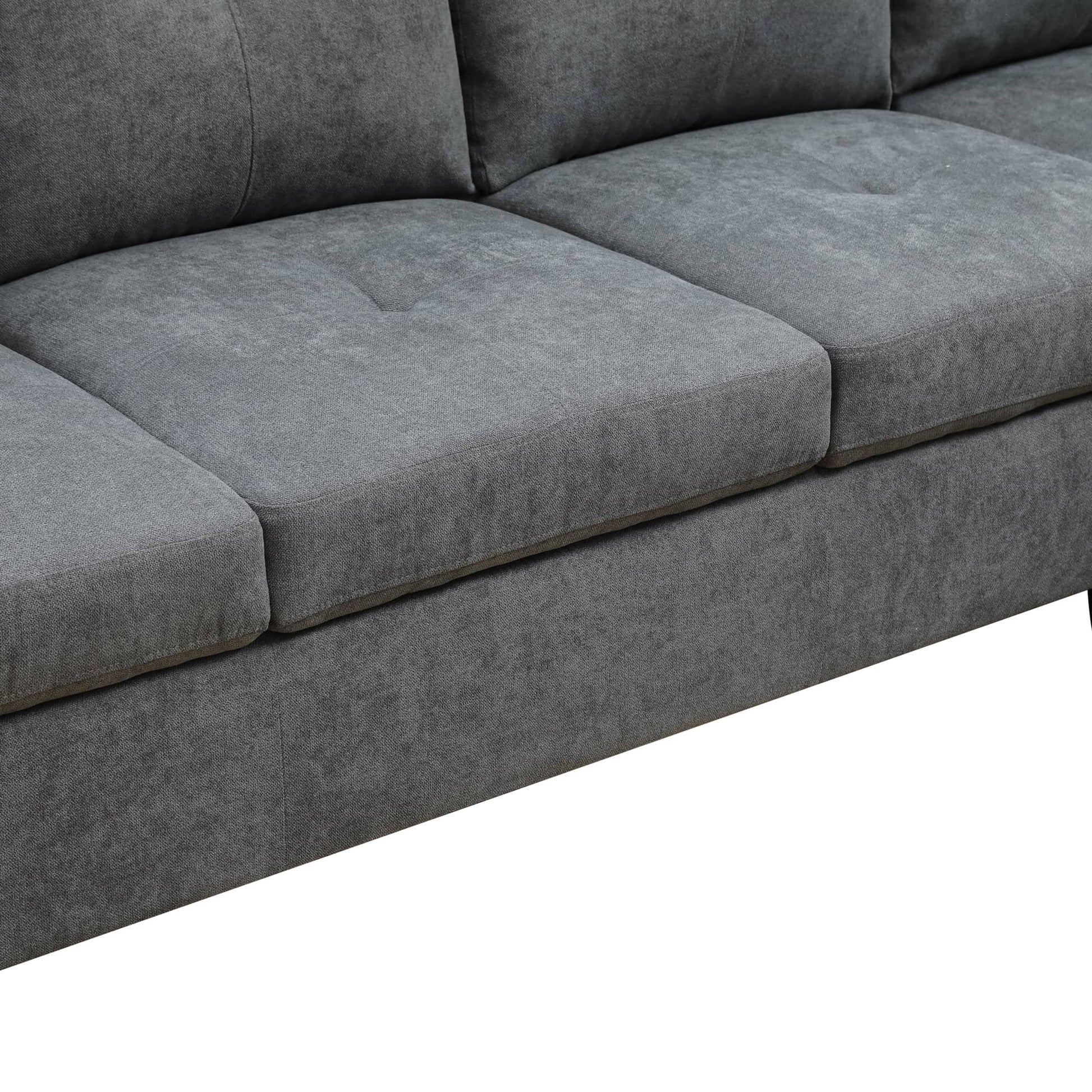 Closeup of grey fabric sofa cushions with subtle tufting