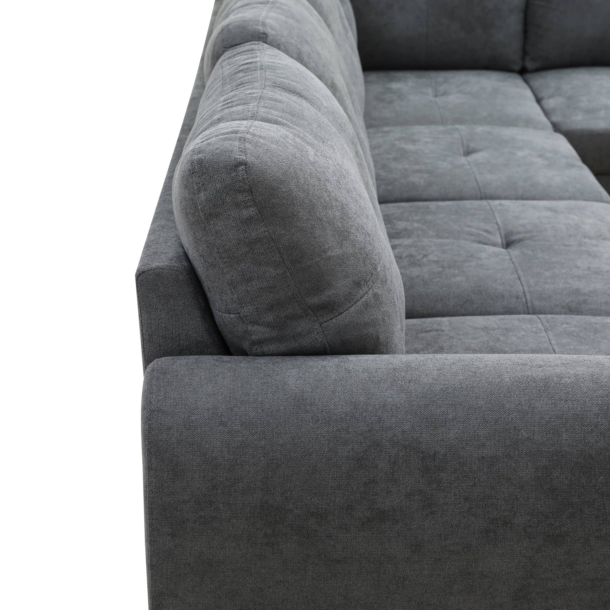 Closeup of deep grey fabric sectional sofa armrest and cushion