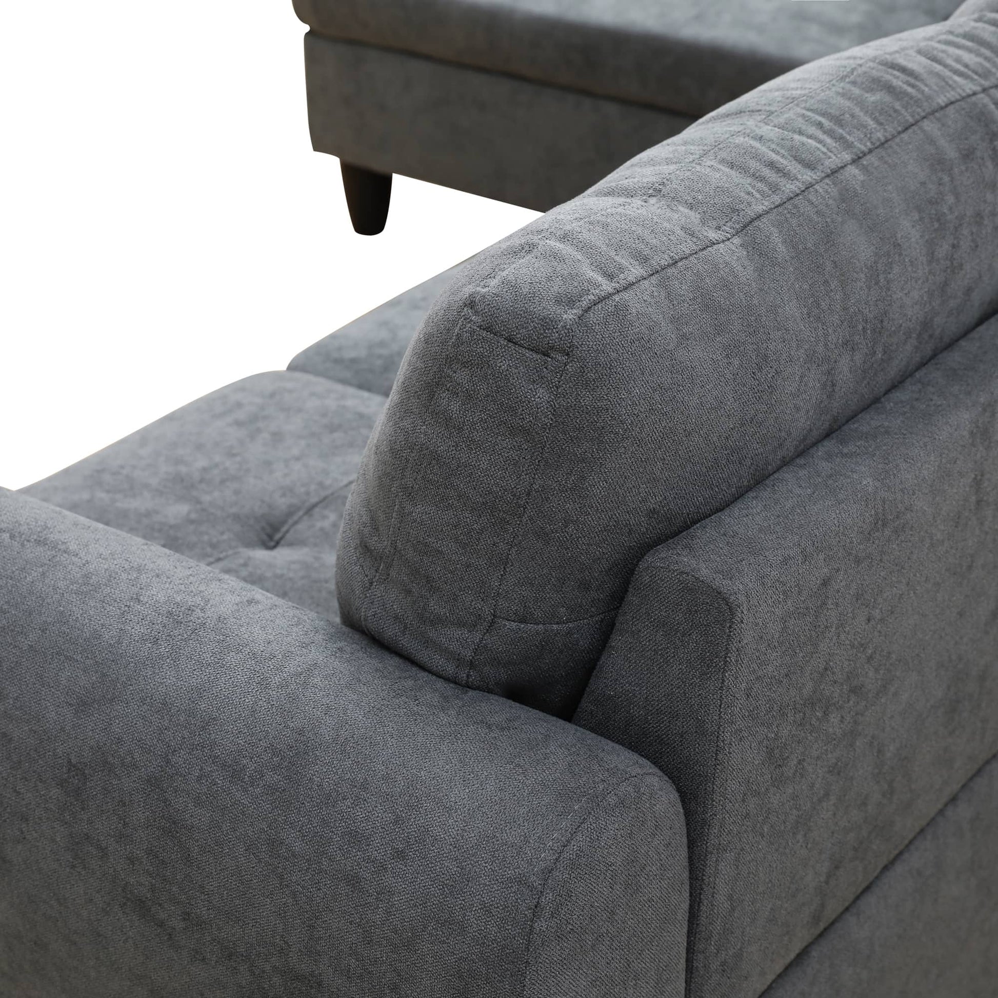 Grey fabric sectional sofa armrest with tufted seat detail