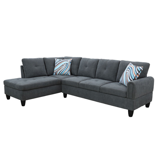 Dark grey fabric sectional sofa with tufted seats and two colorful striped accent pillows