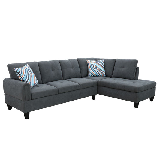 Dark gray fabric sectional sofa with tufted cushions and patterned throw pillows