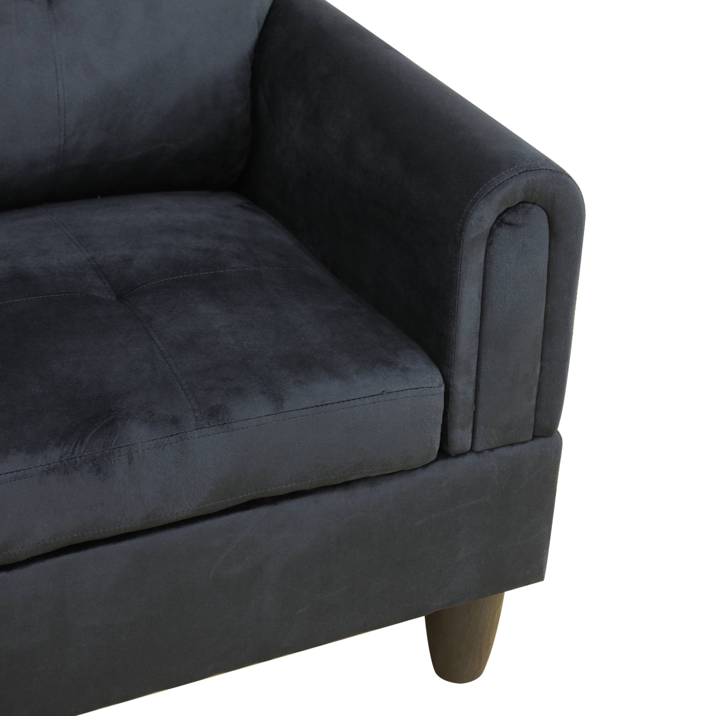 Dark gray velvet tufted sofa corner with rolled armrest
