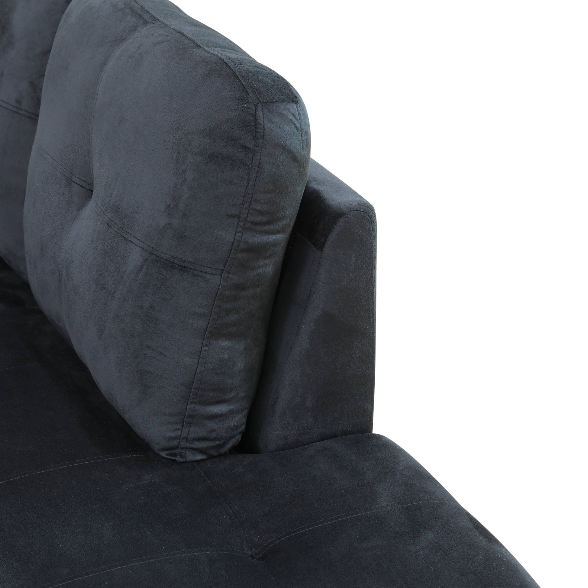 Closeup of dark gray velvet sofa corner with tufted back cushion