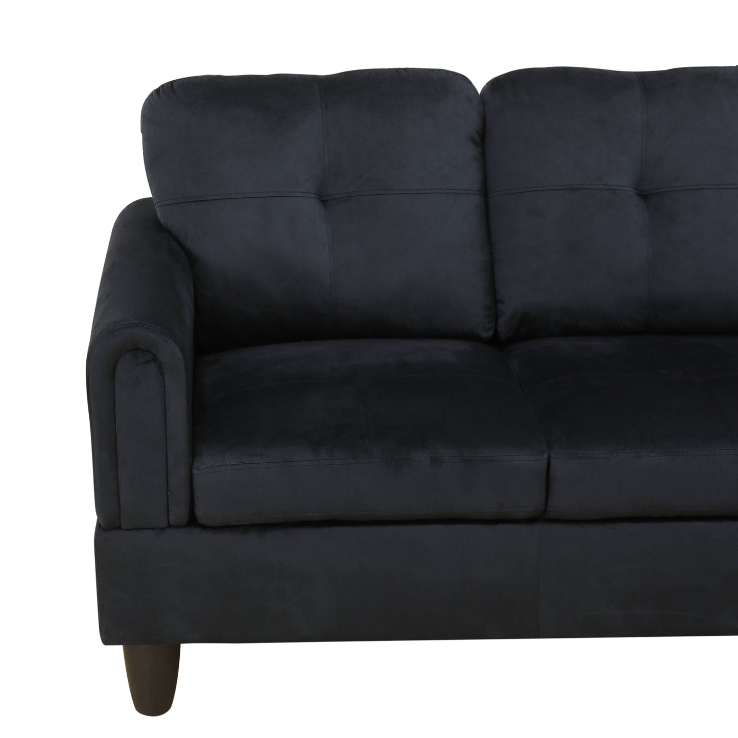 Black velvet sofa with tufted cushions and a rounded armrest