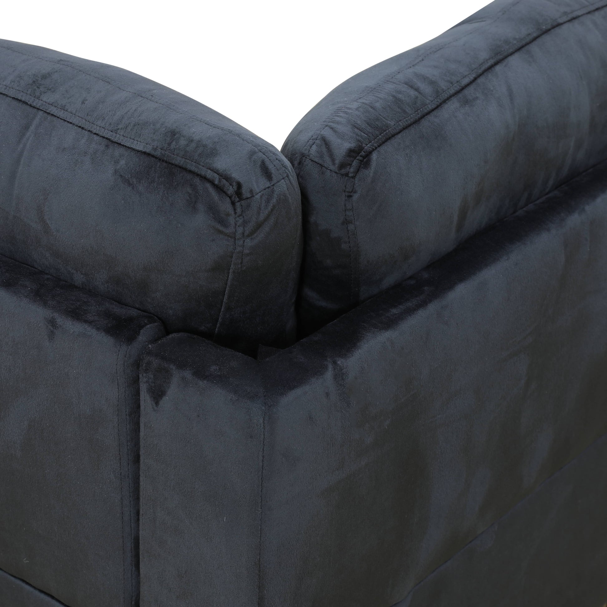 Black velvet sofa corner with plush cushions and clean stitching