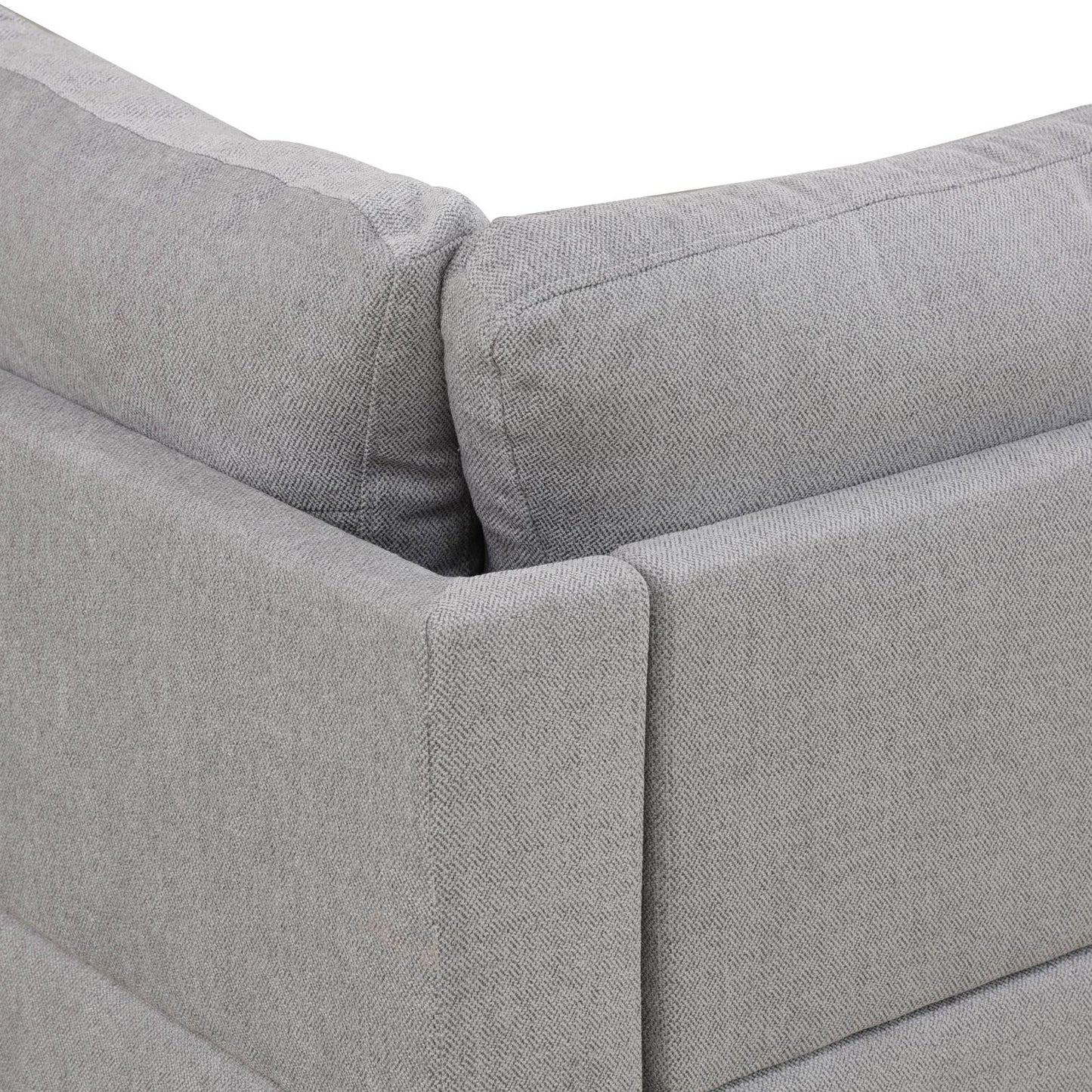 Closeup of a textured grey fabric sofa armrest with visible stitching