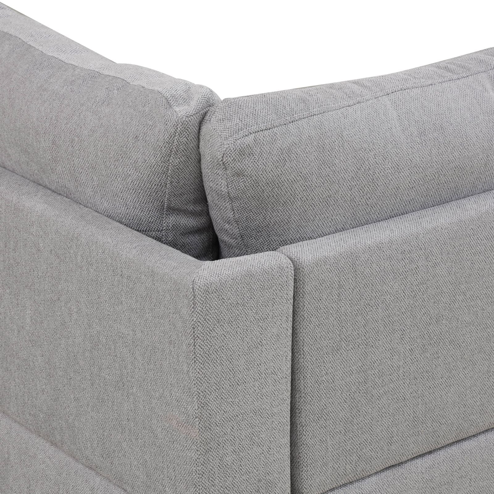 Closeup of a textured grey fabric sofa armrest with visible stitching