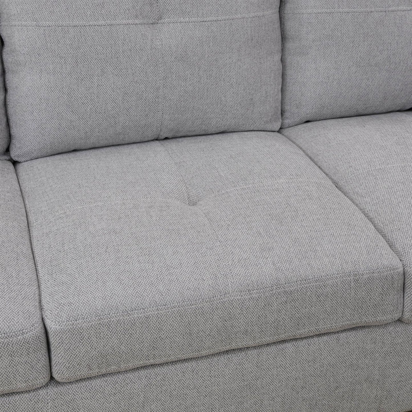 Closeup of a textured grey fabric sofa cushion with subtle herringbone weave