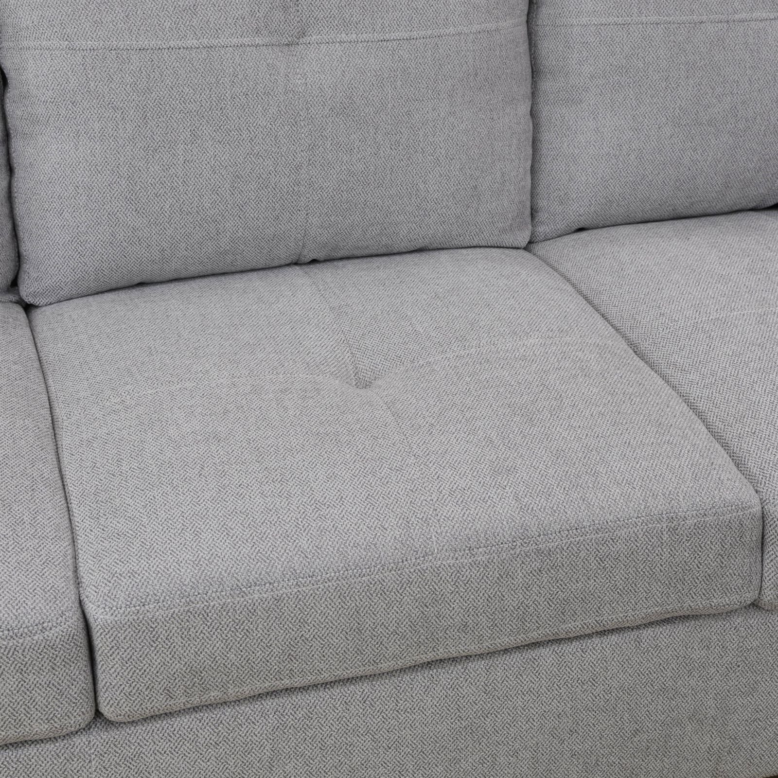 Closeup of a textured grey fabric sofa cushion with subtle herringbone weave
