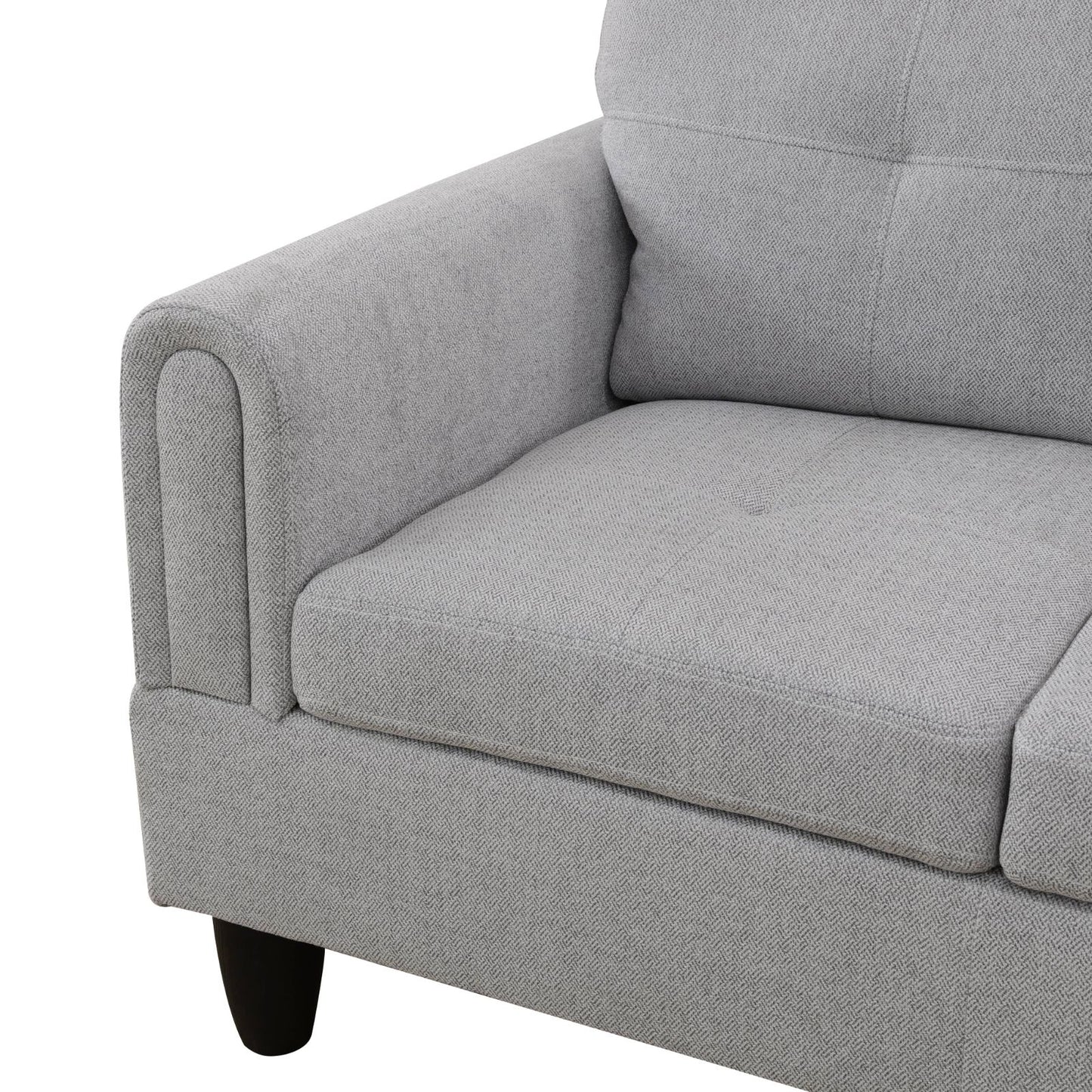 Closeup of a modern grey fabric sofa armrest with tufted details