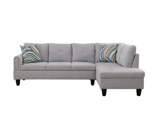 Grey fabric sectional sofa with tufted cushions and colorful throw pillows