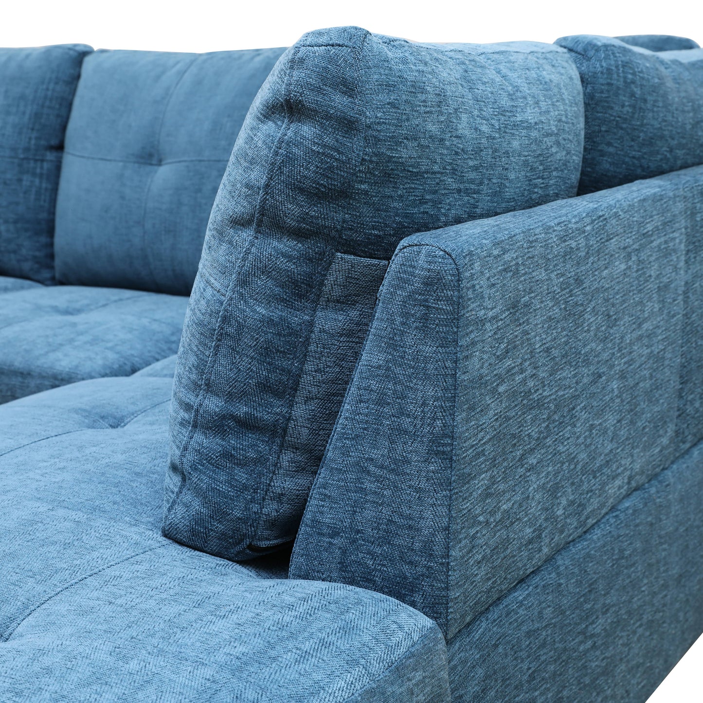Closeup of a textured blue fabric sectional sofa armrest and cushion
