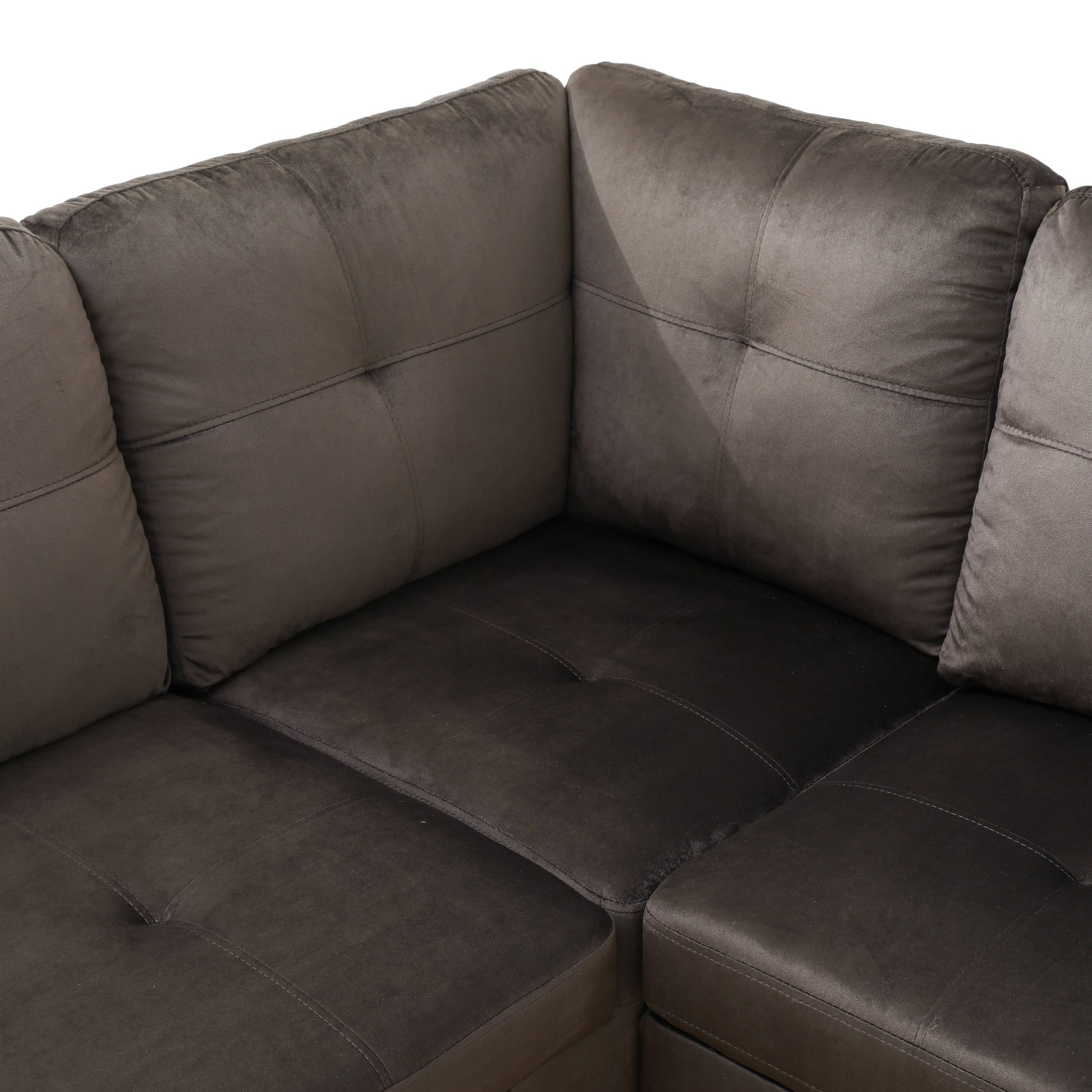 Dark gray velvet sectional sofa with tufted cushions and contrast stitching