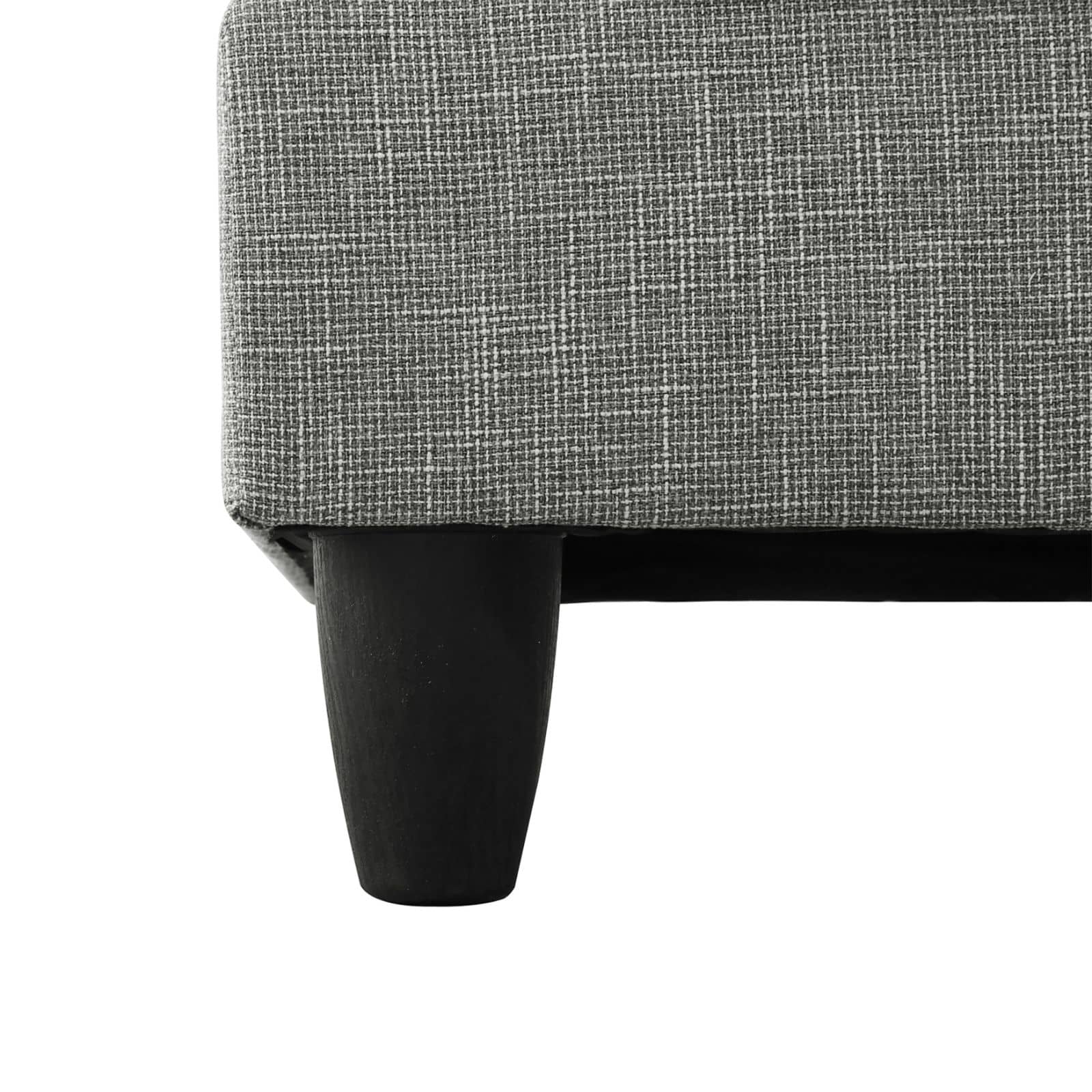 Close up of grey textured fabric upholstery on a furniture piece with dark wooden legs