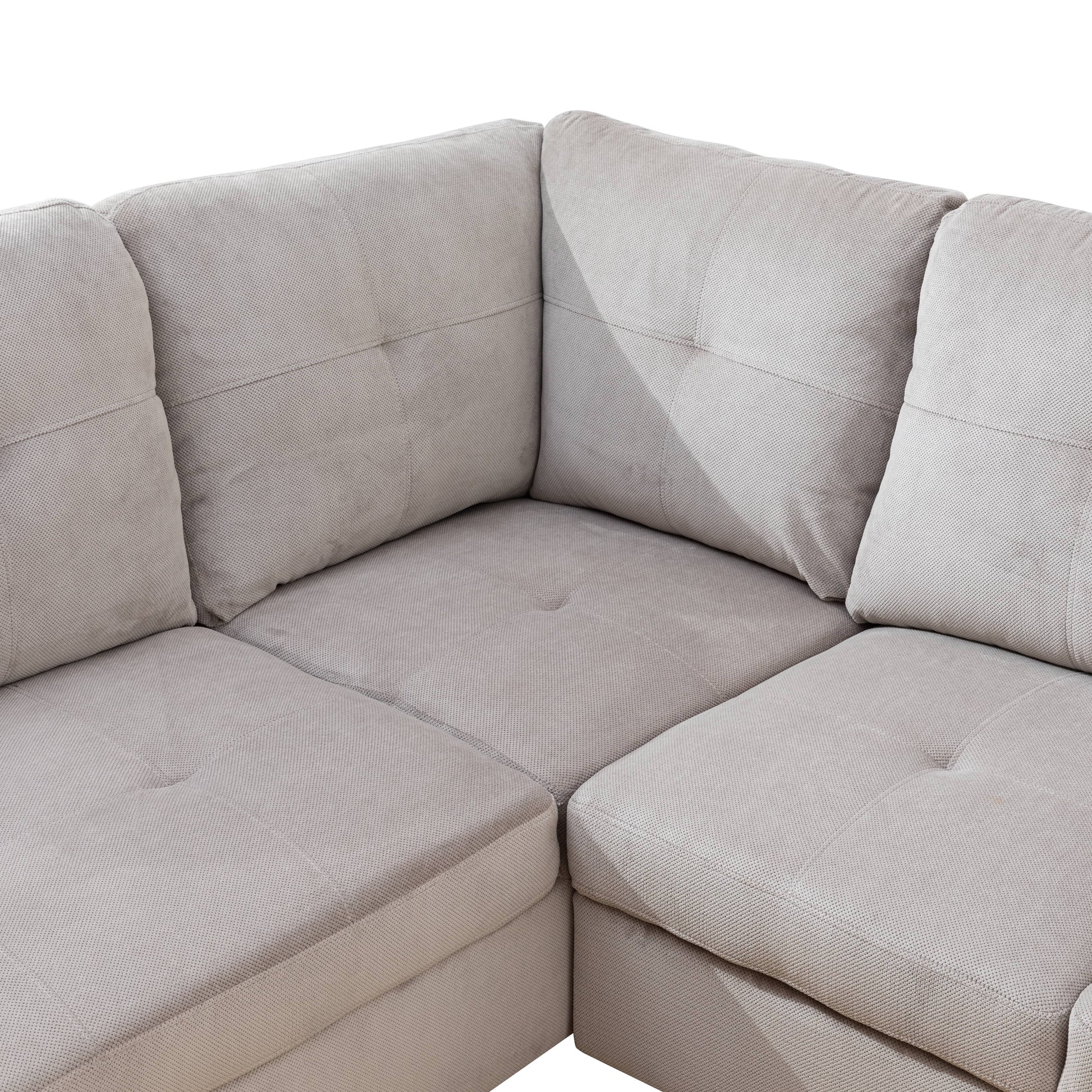 Light beige fabric sectional sofa with tufted cushions and textured upholstery