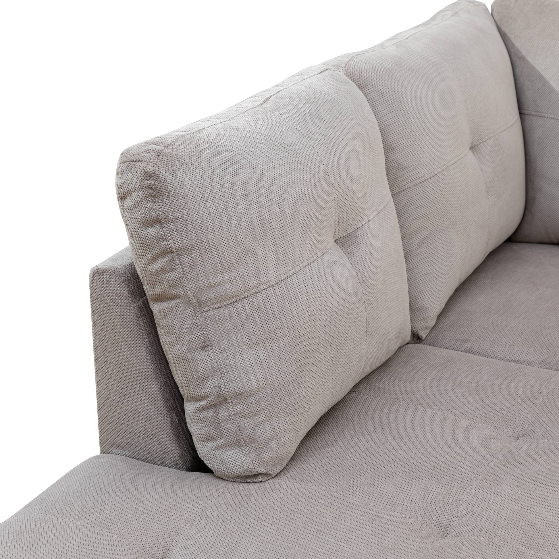 Textured gray fabric sofa armrest with tufted cushion detail