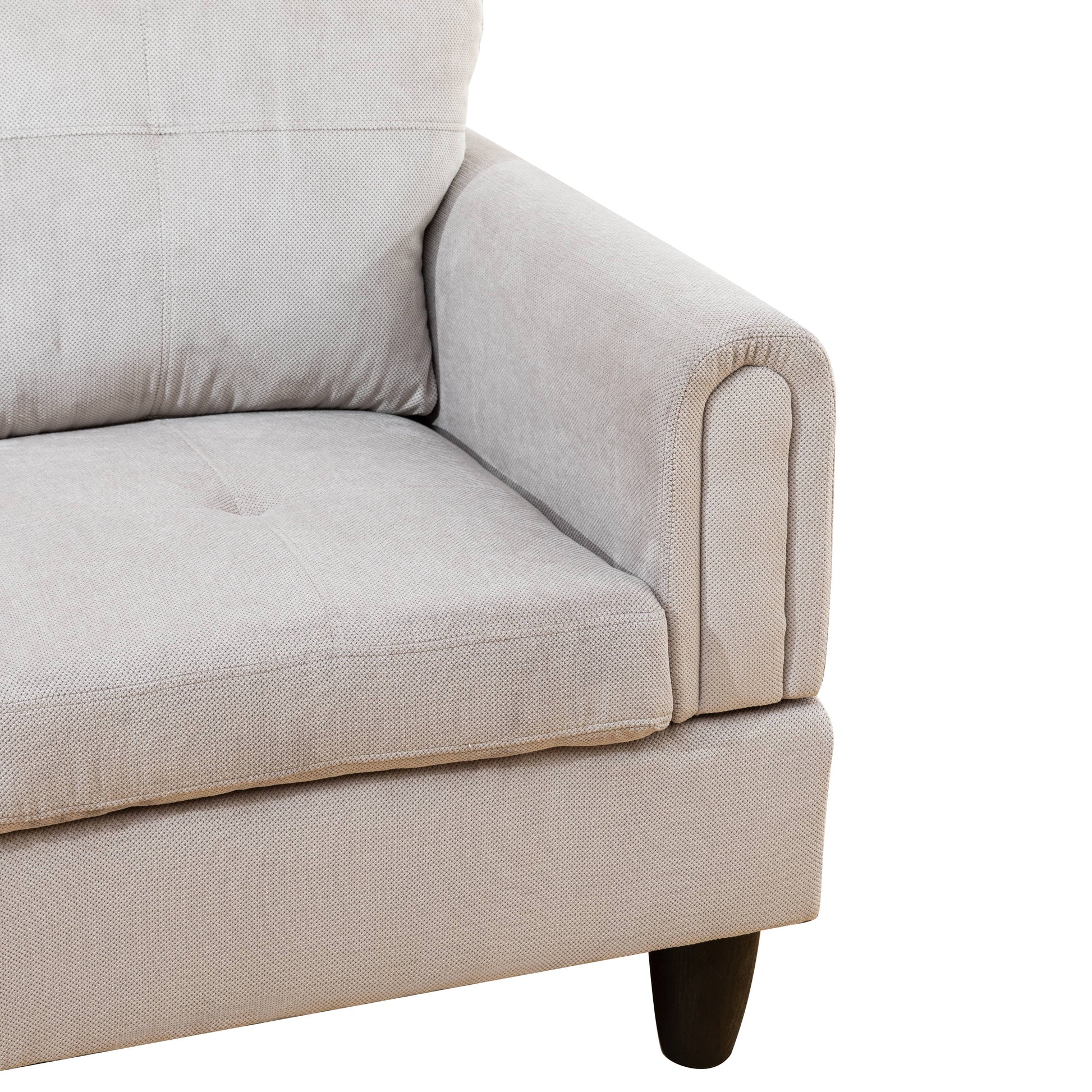 Closeup of textured beige fabric sofa armrest with button tufting