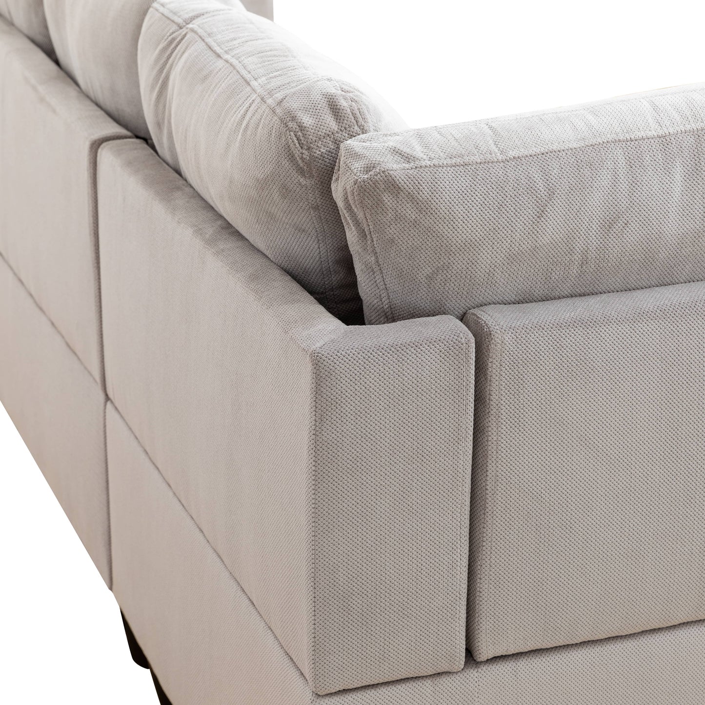 Closeup of a light gray textured fabric sofa corner with plush cushions