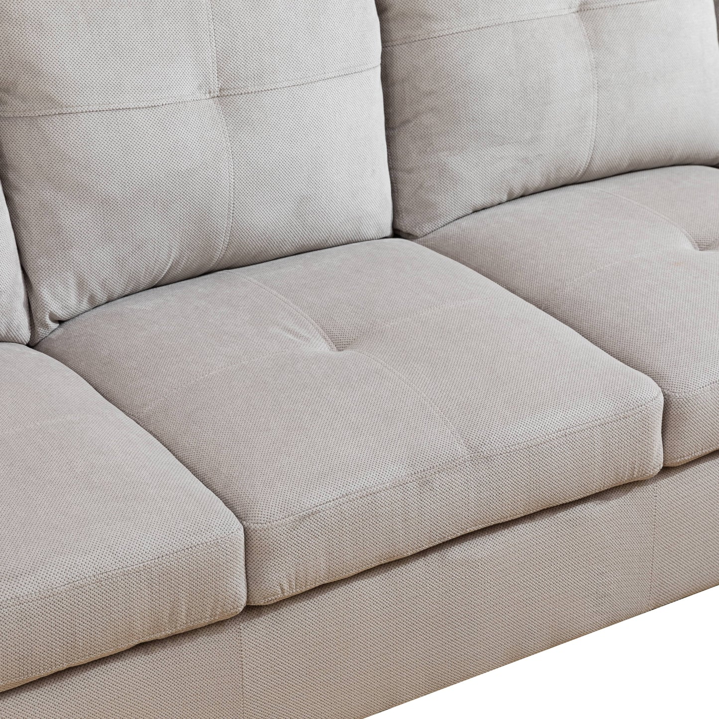 Close up of a light gray fabric sofa with tufted cushions