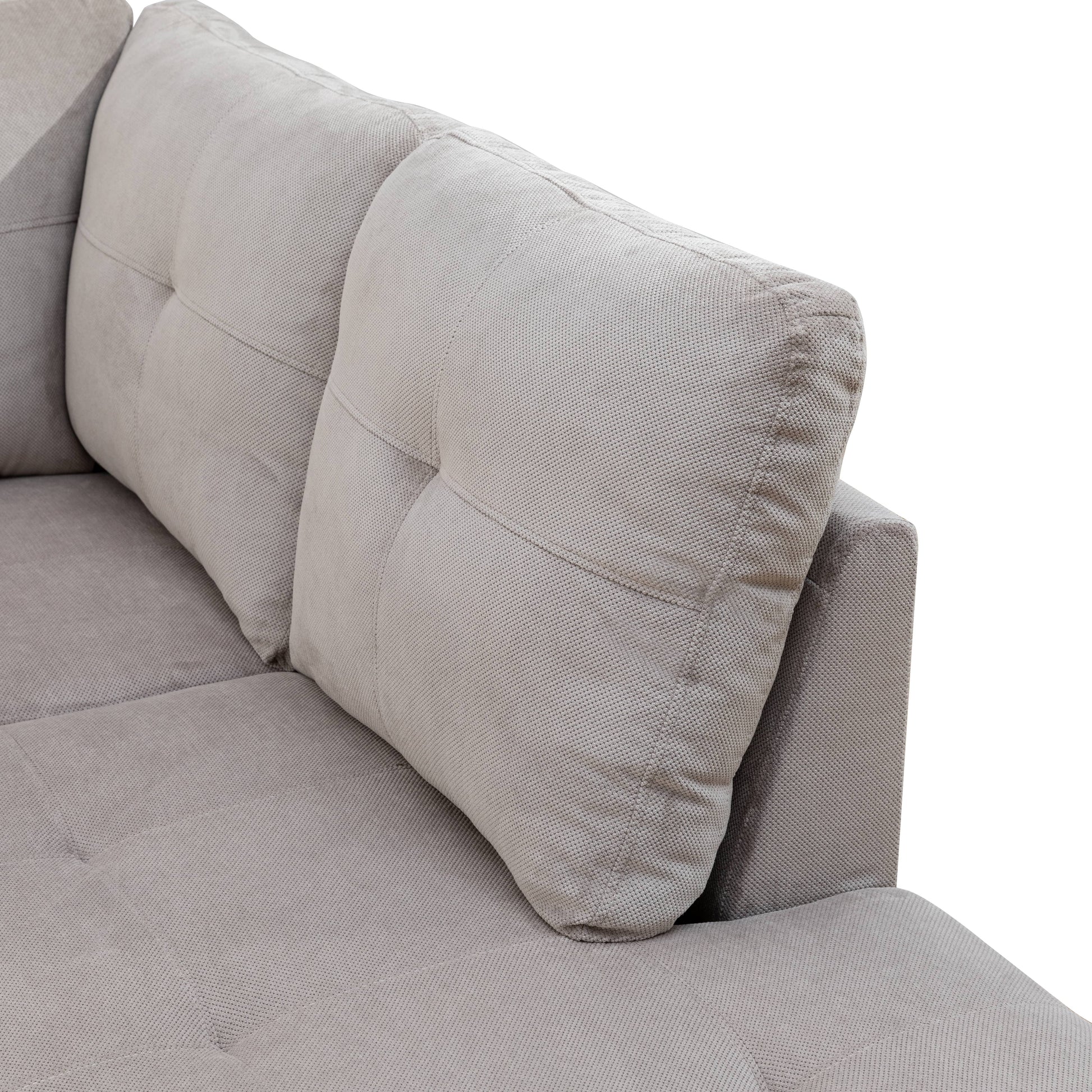 Closeup of a tufted grey fabric sofa cushion