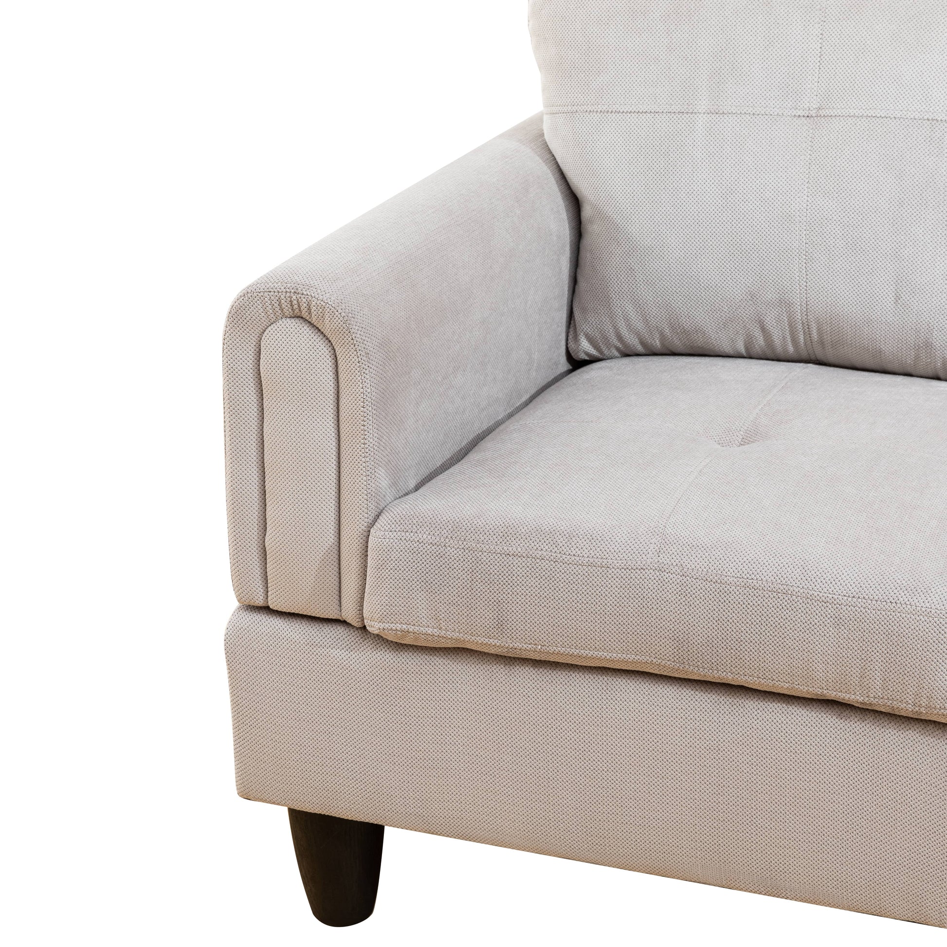 Closeup of a textured beige fabric sofa armrest with dark wooden legs