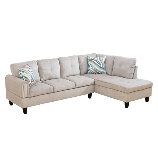Light gray fabric sectional sofa with tufted cushions and patterned accent pillows