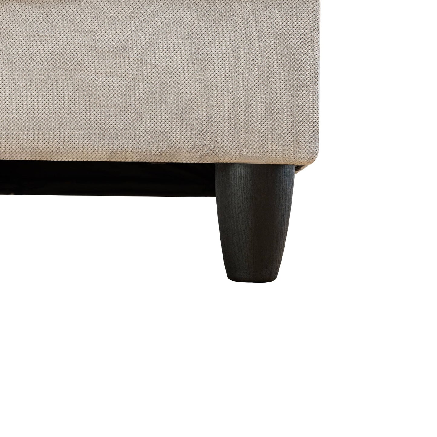 Beige textured fabric sofa detail with dark wood tapered legs