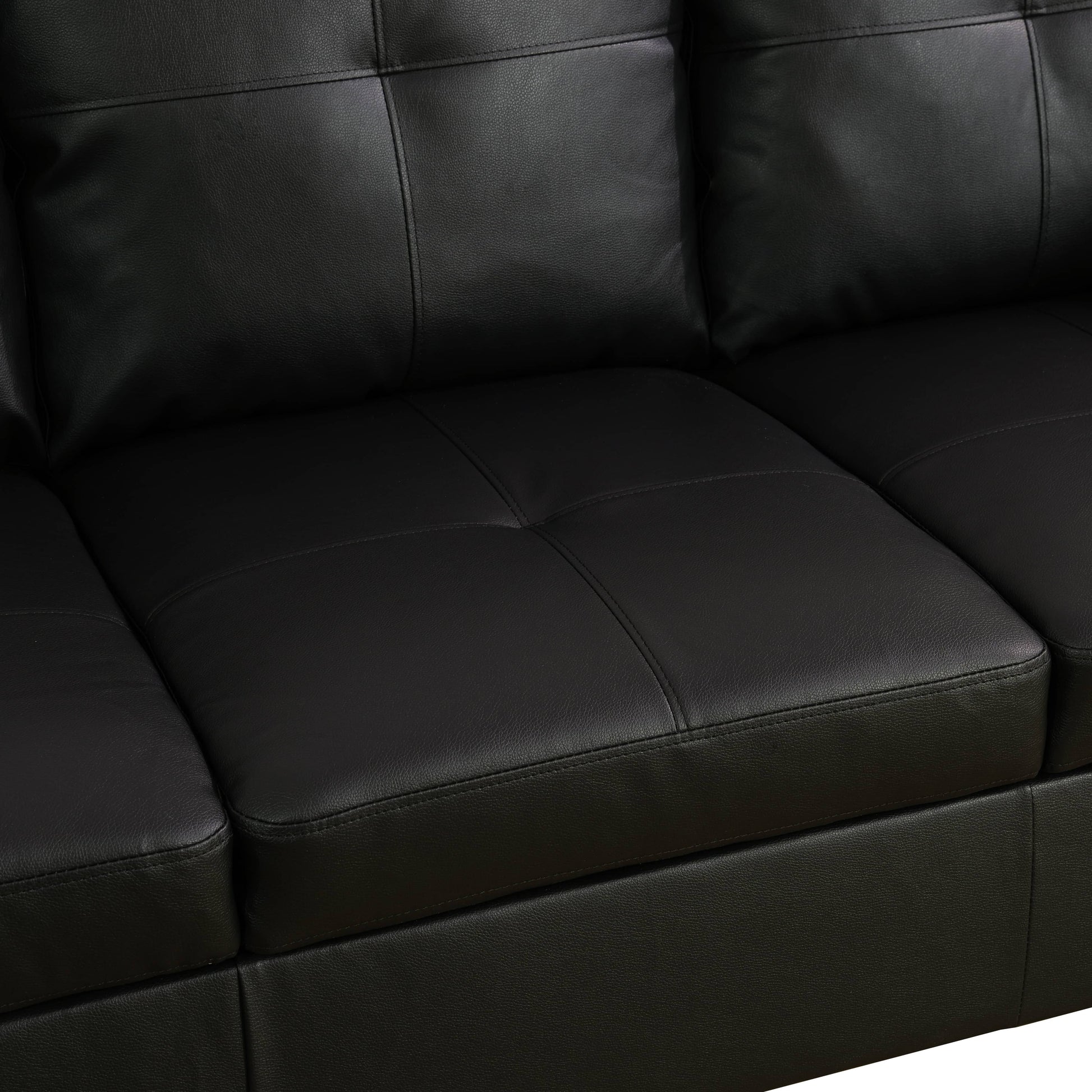 Closeup of a stitched black leather sofa seat cushion with subtle texture