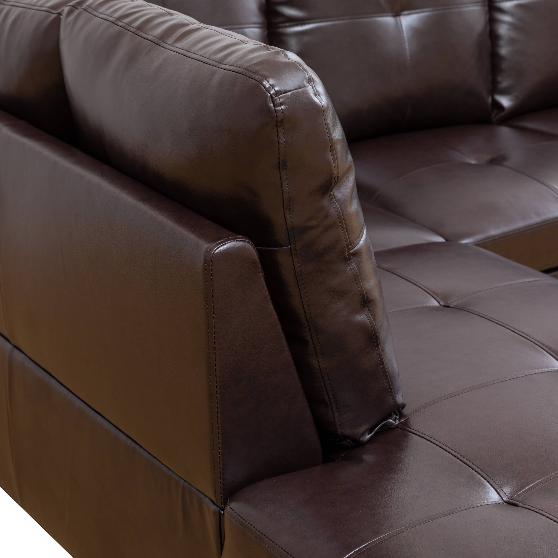 Tufted brown faux leather sofa armrest and cushion detail
