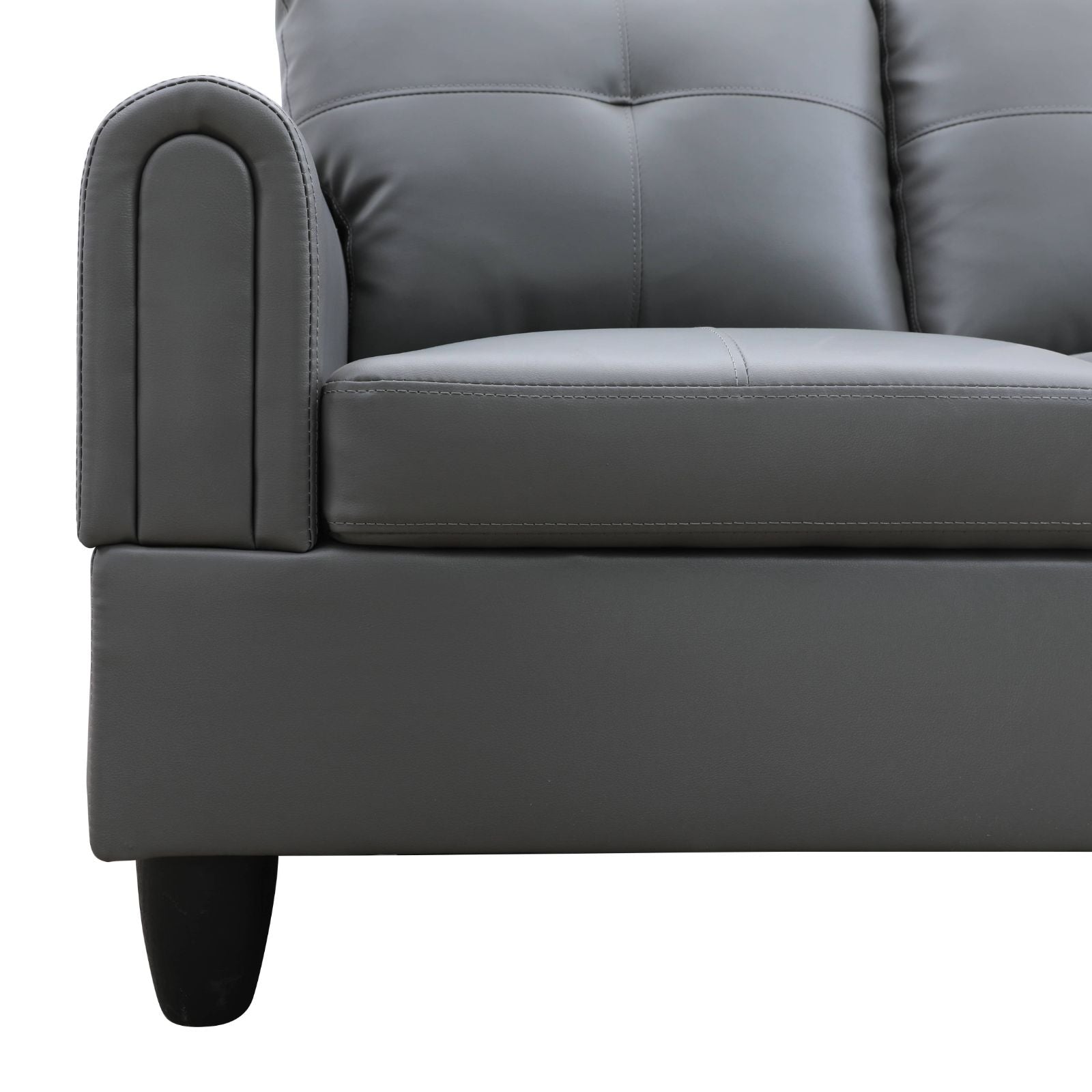 Gray faux leather sofa with tufted back cushions and arched armrest
