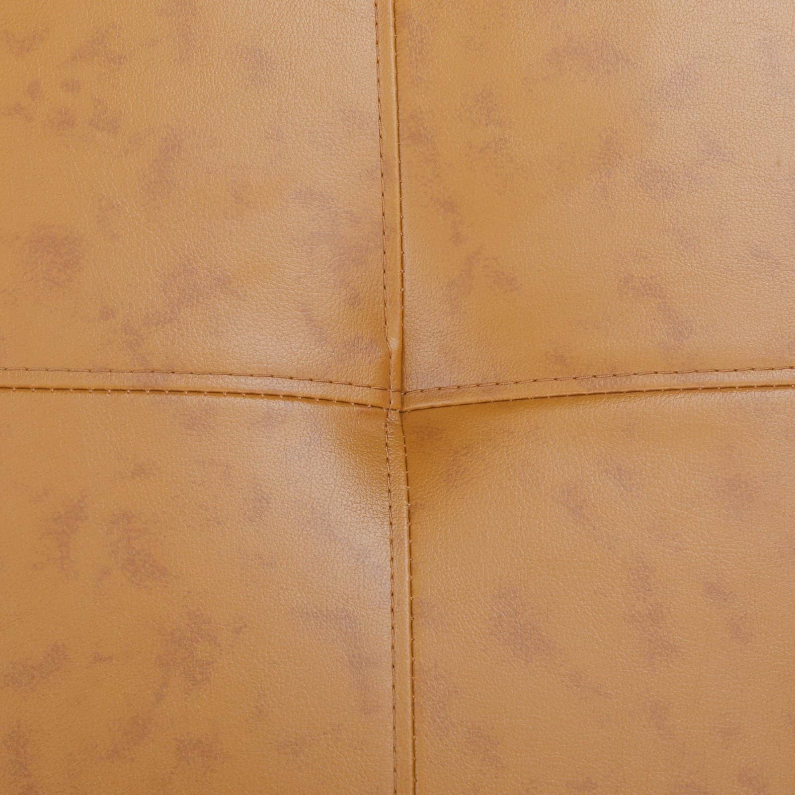 Closeup of tan faux leather upholstery with subtle distressing and stitching