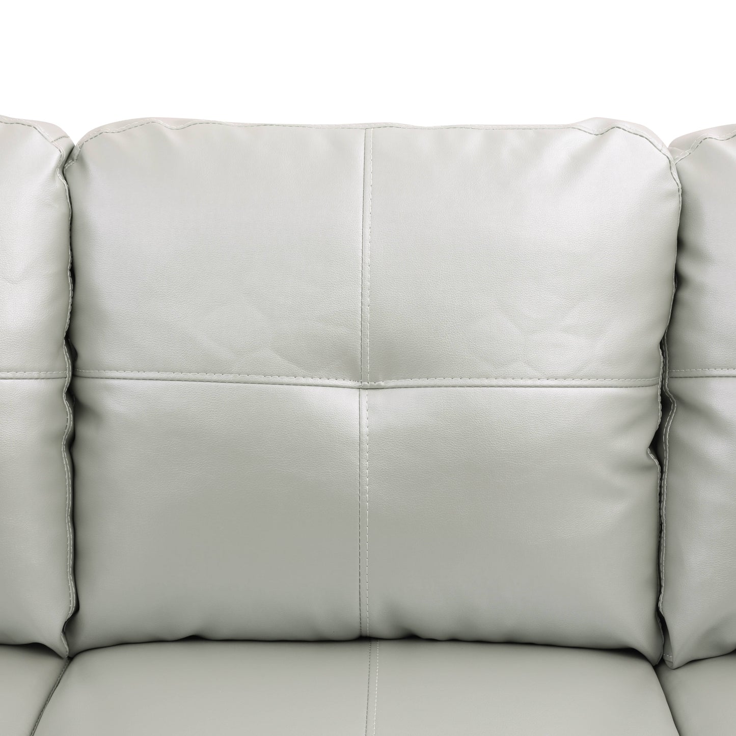 Closeup of a plush light grey faux leather sofa with stitched diamond pattern