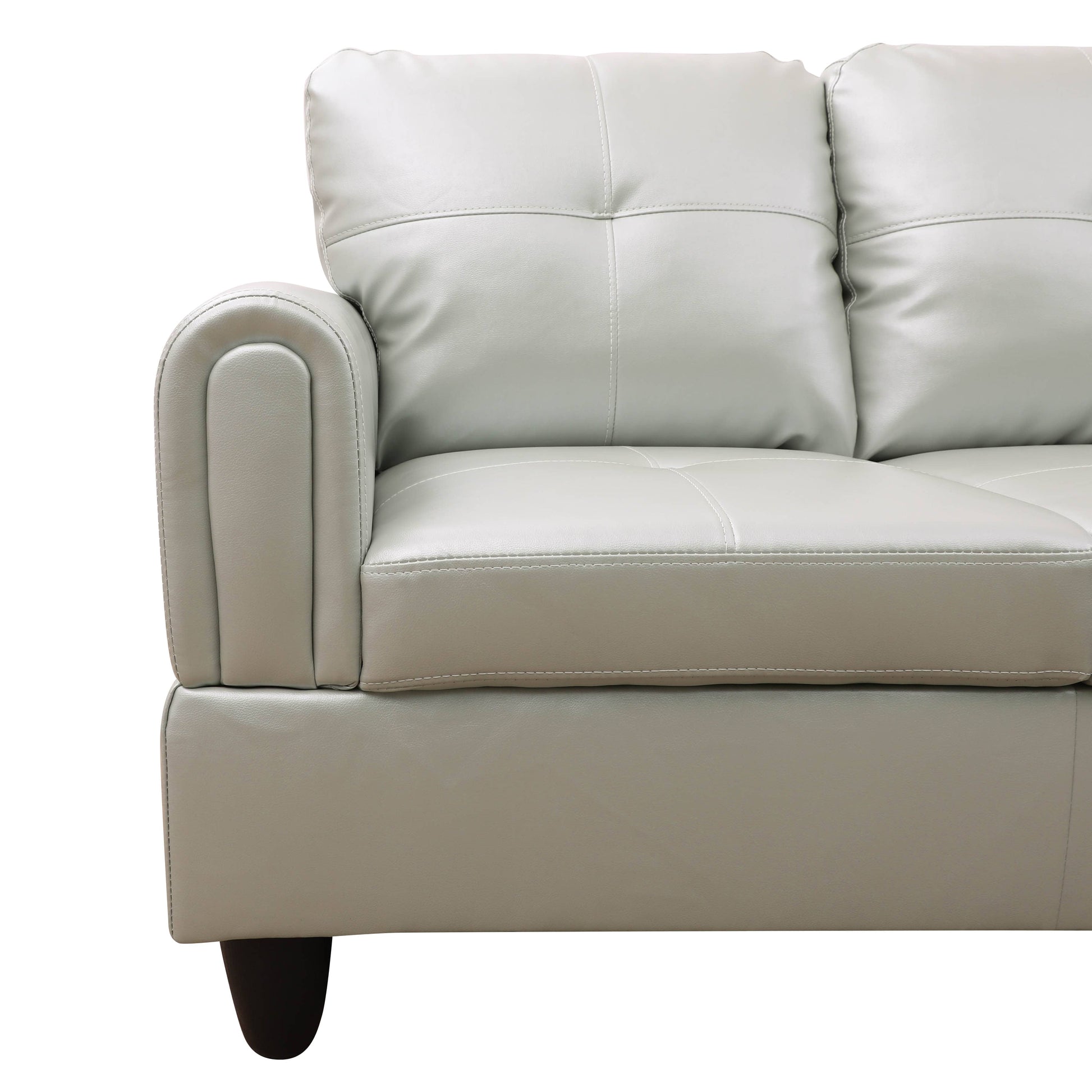Light gray leather couch with quilted back cushions and a curved armrest