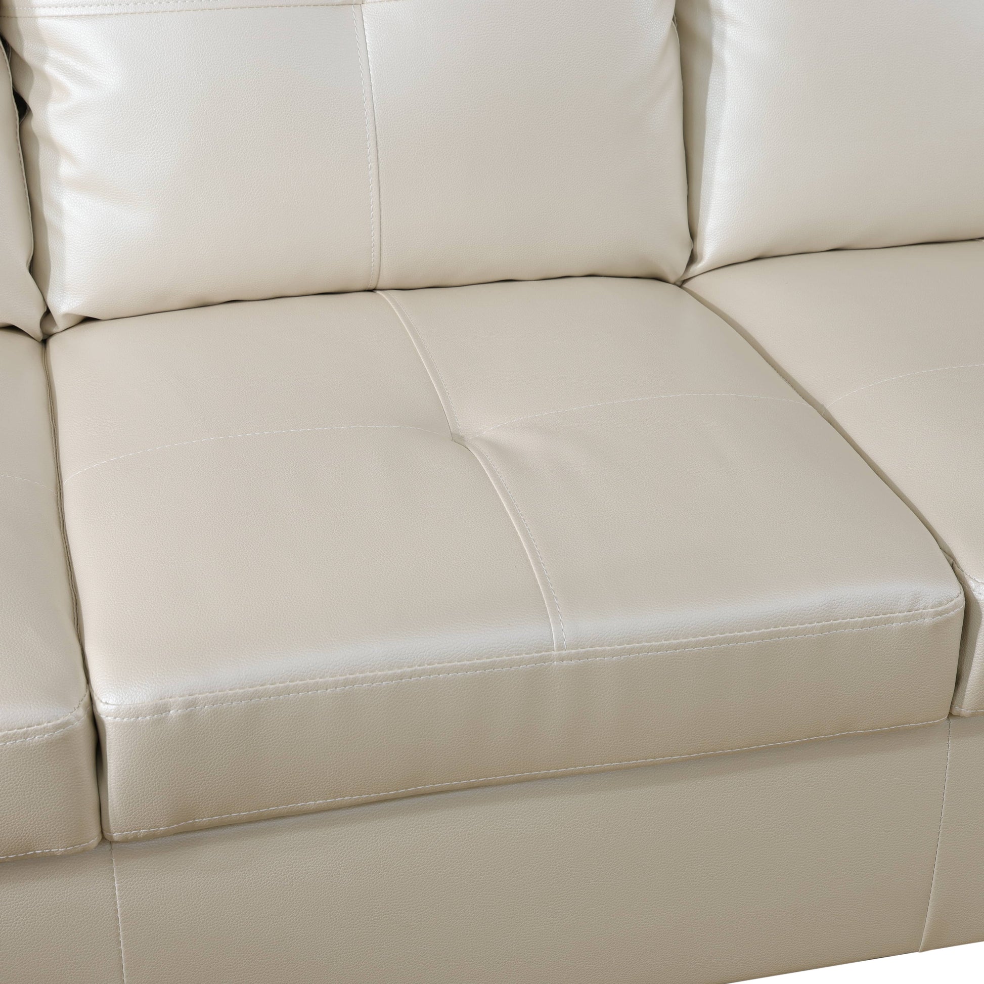 Closeup of cream leather sectional sofa cushions with stitched detailing