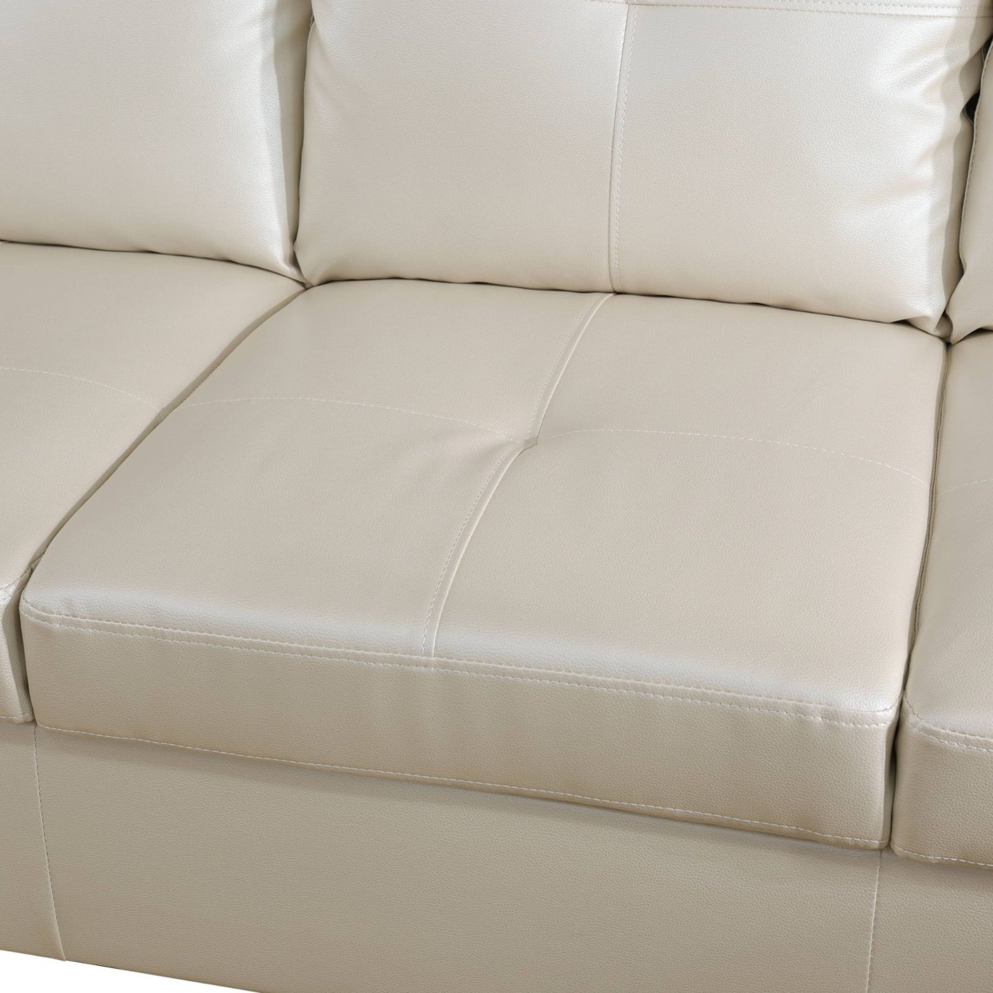 Cream faux leather sectional sofa with button tufting and stitched detailing