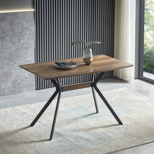 Wooden dining table with black metal legs and stack of plates