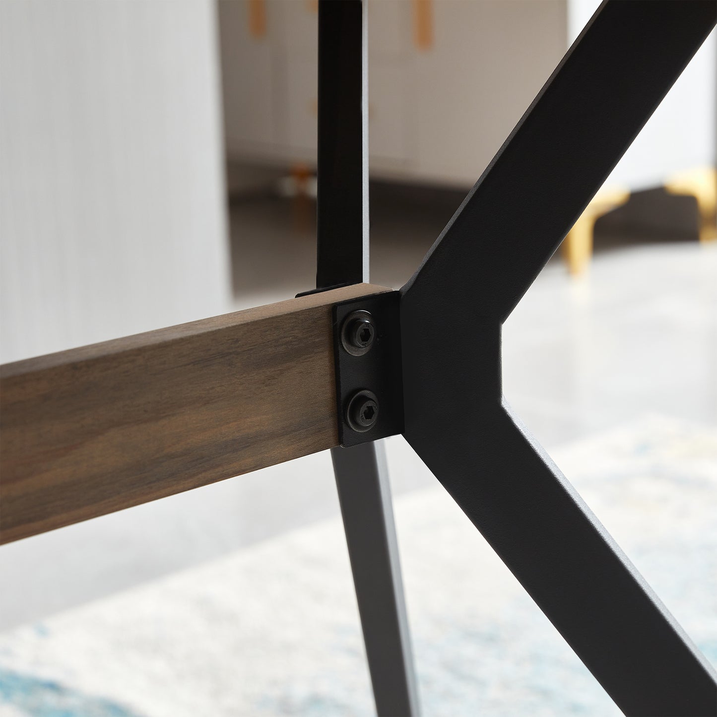 Closeup of rustic wood grain table support connected by black metal brackets and bolts