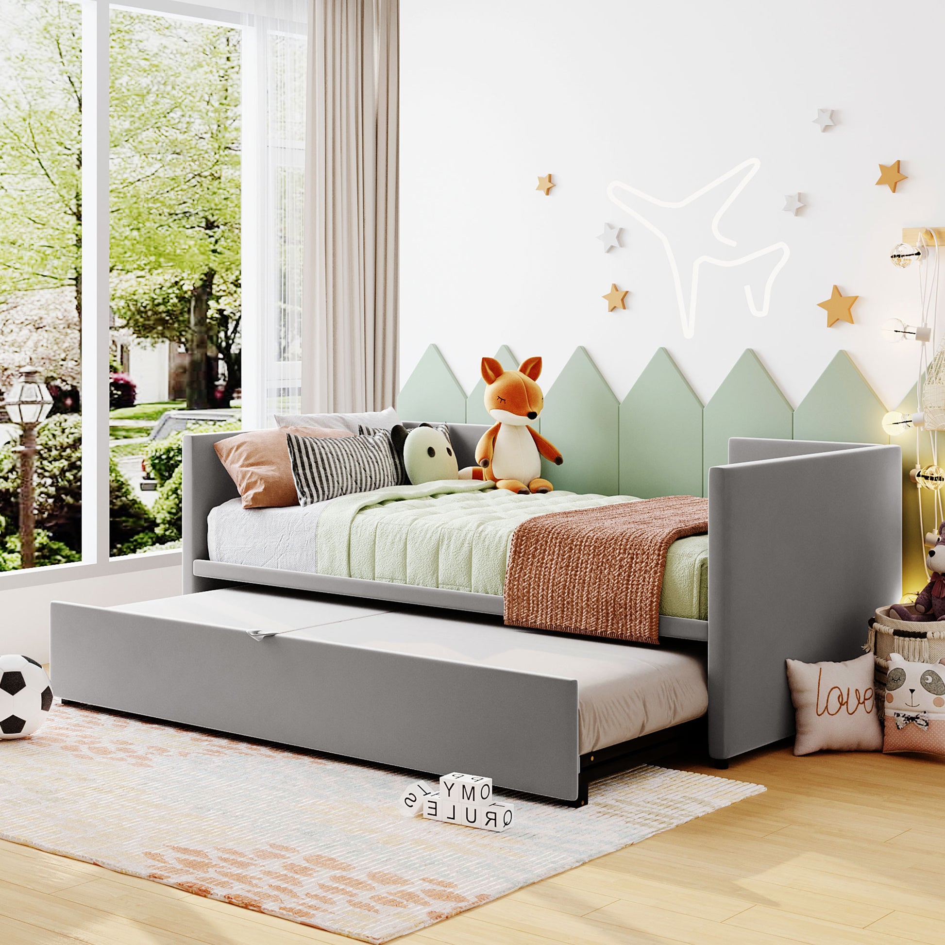 Gray upholstered daybed with a pullout trundle perfect for kids rooms